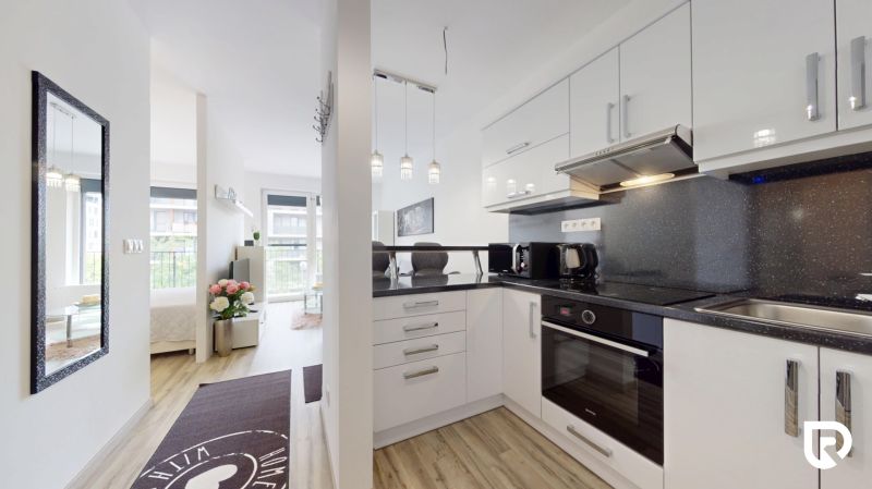 | Zariadený 1,5 izbový byt | 35m² | SLNEČNICE - Kuchyňa a obývací priestor v 2-izbovom byte s moderným zariadením a výhľadom.