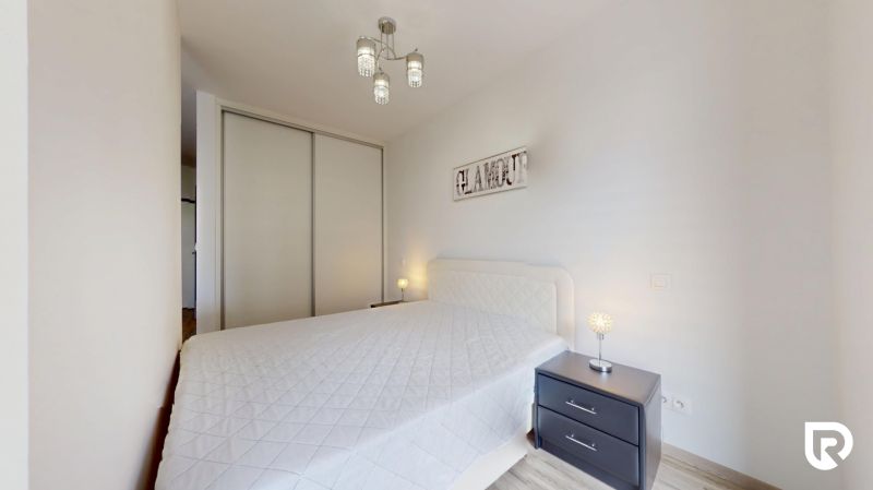 | Zariadený 1,5 izbový byt | 35m² | SLNEČNICE - Spálňa s manželskou posteľou, nočnými stolíkmi a vstavanou skriňou v 2-izbovom byte.