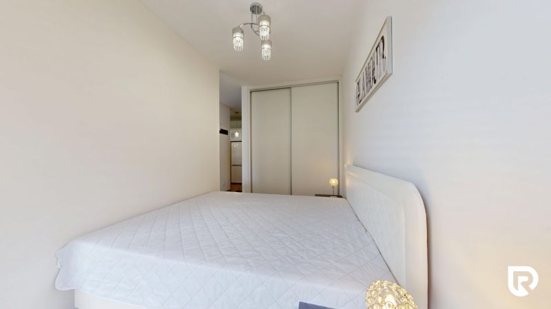 | Zariadený 1,5 izbový byt | 35m² | SLNEČNICE - Svetlá spálňa s manželskou posteľou a vstavanou skriňou v 2-izbovom byte.
