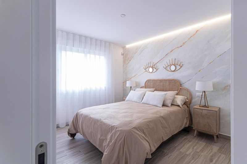 Predaj- Apartmány - La Manga del Mar Menor- Španielsko  - Spálňa v rekreačnom apartmáne s posteľou, látkovými závesmi a podlahou s dreveným dekorom.