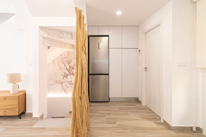 Predaj- Apartmány - La Manga del Mar Menor- Španielsko  - Interiér rekreačného apartmánu s kuchynskými skrinkami, chladničkou a podlahou s dreveným dekorom.