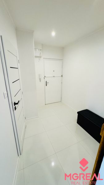 Na predaj 1 i byt 35 m2 v Partizánskom – Šípok, komplet rekonštrukcia - Biela vstupná chodba s dlažbou a tmavou lavicou v 1-izbovom byte.