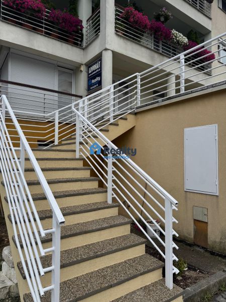 Prenájom kanc./obchodné priestory, nová kompl. rekonšt., centrum PB - V Považskej Bystrici vedú schody ku kanceláriám s kvetinovou výzdobou na balkóne.
