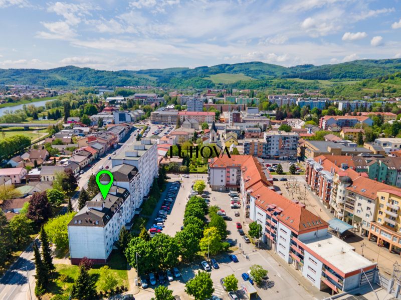 Charizmatický 2-izbový byt na bývanie alebo prenájom | Mudroňova ulica - Púchov, Mudroňova ulica: letecký pohľad na obytné a komerčné budovy v okolí.