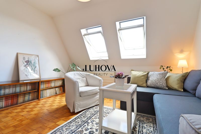 Charizmatický 2-izbový byt na bývanie alebo prenájom | Mudroňova ulica - Obývačka v 2-izbovom byte s podlahou s dreveným dekorom, pohodlným gaučom a kreslom.