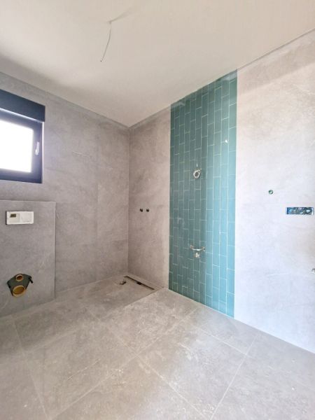 CHORVÁTSKO - Apartmány 60 m od mora - PRIVLAKA - Kúpeľňa v 3-izbovom byte so sivými obkladmi a modrou mozaikou na stene.