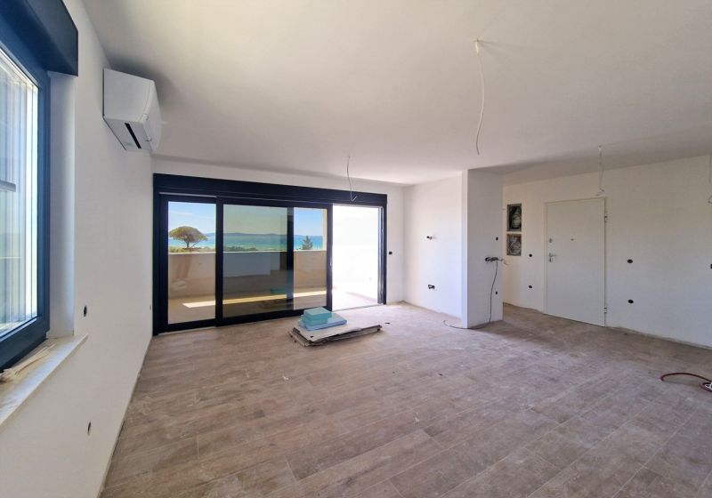 CHORVÁTSKO - Apartmány 60 m od mora - PRIVLAKA - Priestranný obývací priestor s podlahou s dreveným dekorom v 3-izbovom byte.