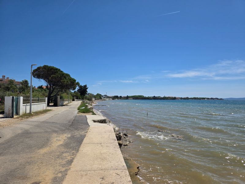 CHORVÁTSKO - Apartmány 60 m od mora - PRIVLAKA - Pobrežná cesta v Privlake vedie popri mori za slnečného počasia.