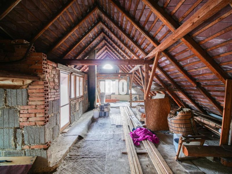 Útulný rodinný dom v príjemnej lokalite - Povala rodinného domu s rozostavanými múrmi a drevenou konštrukciou strechy.