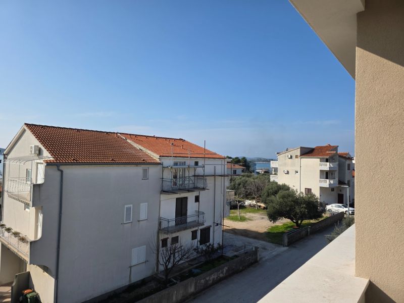 CHORVÁTSKO - Apartmány 140 m od pláže (3i) - VODICE - Výhľad z 3-izbového bytu na budovy a more v meste Vodice.