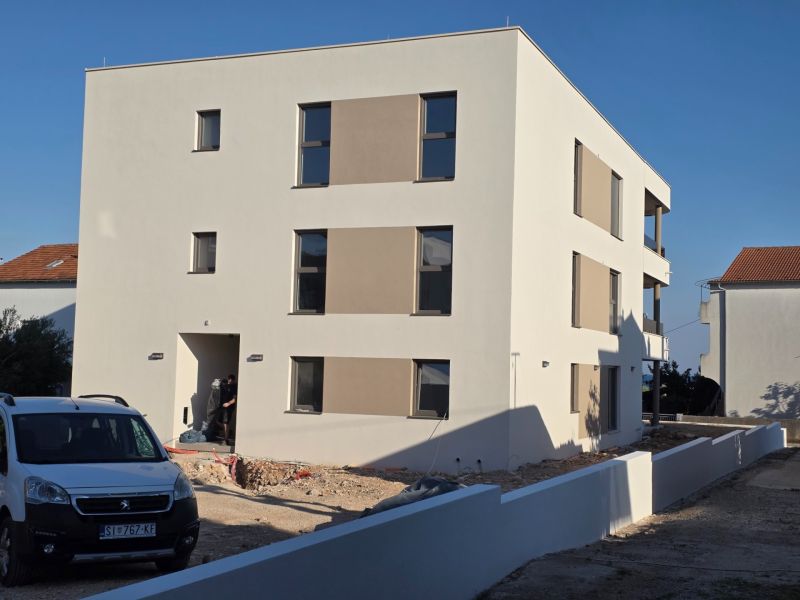 CHORVÁTSKO - Apartmány 140 m od pláže (3i) - VODICE - Exteriér 3-izbového bytu v meste Vodice s modernou architektúrou a bielou fasádou.