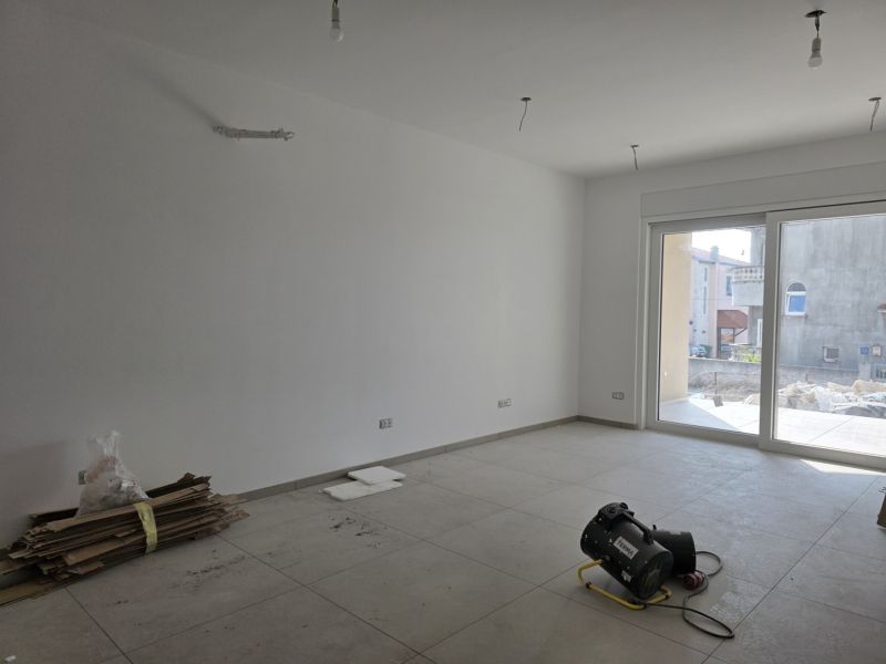 CHORVÁTSKO - Apartmány 140 m od pláže (3i) - VODICE - Svetlá miestnosť s veľkými oknami, neutrálna podlaha a stavebný materiál.