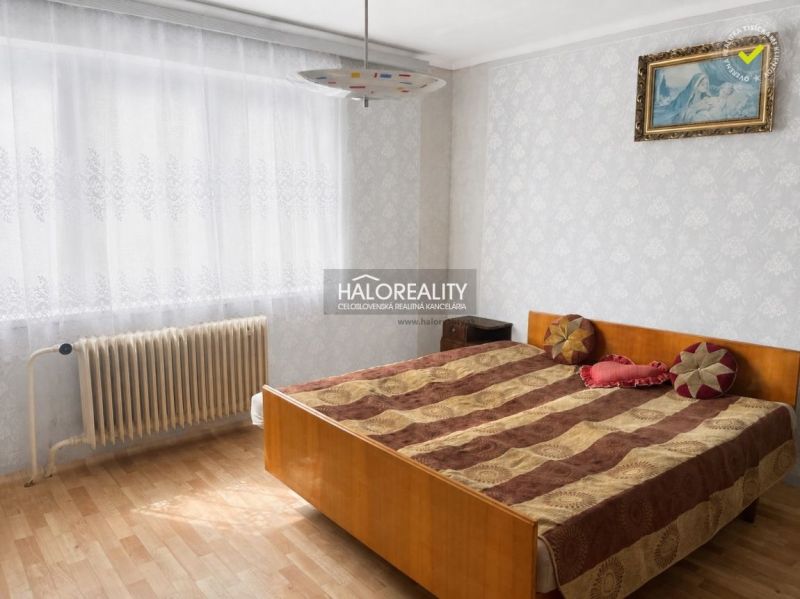 Predaj, rodinný dom Ivanka pri Nitre - Spálňa v rodinnom dome s podlahou s dreveným dekorom a radiátorom pri okne.