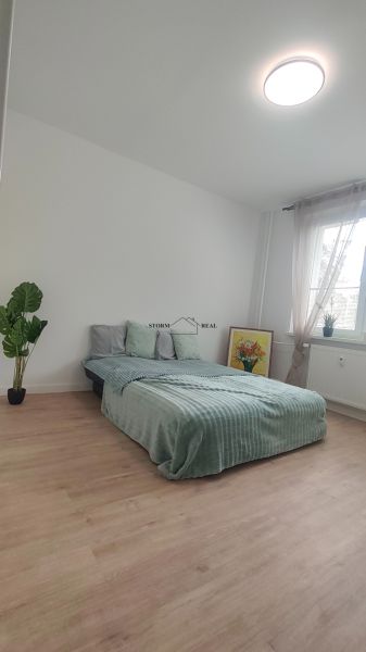 NANOVO KOMPLETNE ZREKONŠTRUOVANÝ ešte NEOBÝVANÝ 4 IZB. BYT, EXNÁROVA - Spálňa v 4-izbovom byte s posteľou, rastlinou a podlahou s dreveným dekorom.
