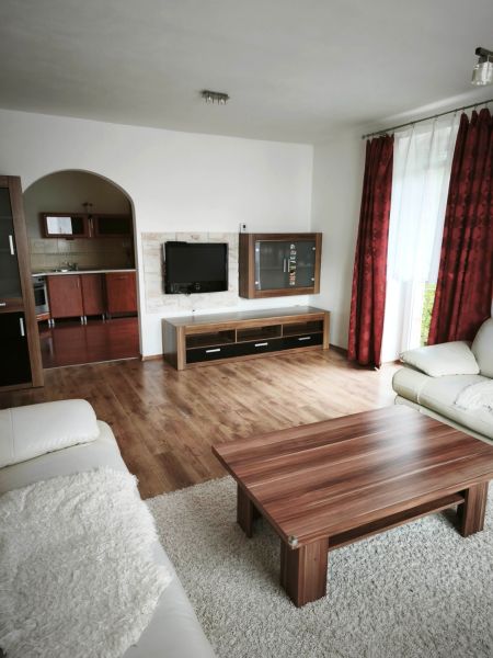 Bungalov za bezkonkurenčnú cenu Martin n. Žitavou - Obývačka v rodinnom dome so sedačkou, stolíkom a podlahou s dreveným dekorom.