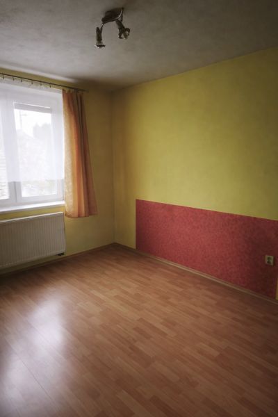 Bungalov za bezkonkurenčnú cenu Martin n. Žitavou - Izba v rodinnom dome s podlahou s dreveným dekorom a farebnou stenou.