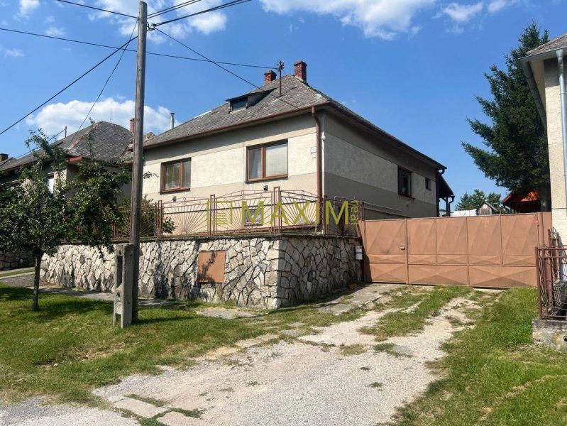Pekný 3 izbový rodinný dom s veľkým pozemkom v Prievaloch - Rodinný dom v Prievaloch s kamenným plotom a kovovou bránou.