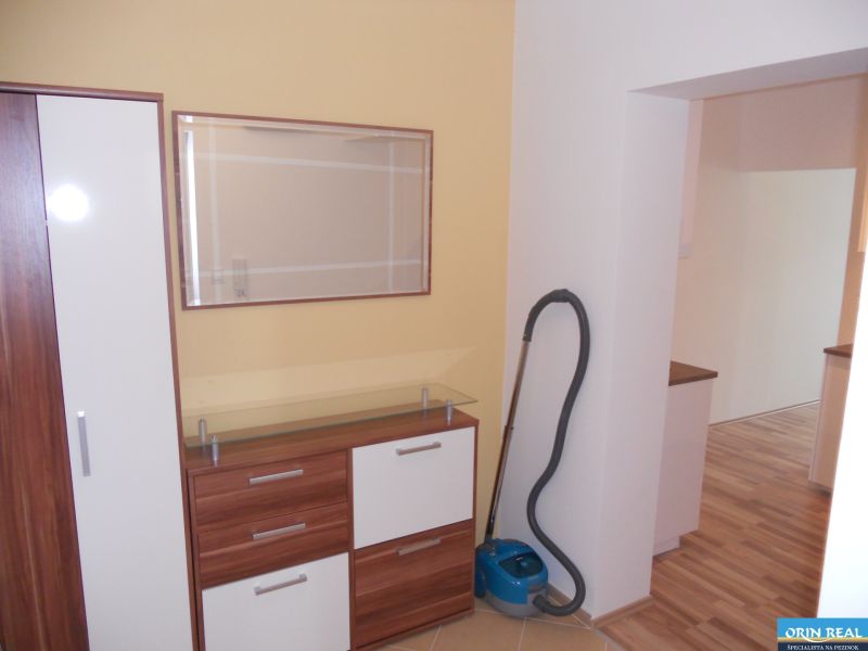 KRÁSNA ZARIADENÁ 1,5 izbová NOVOSTAVBA - Na obrázku je predsieň bytu na ulici Muškátová, skriňa a vysávač v 2-izbovom byte.