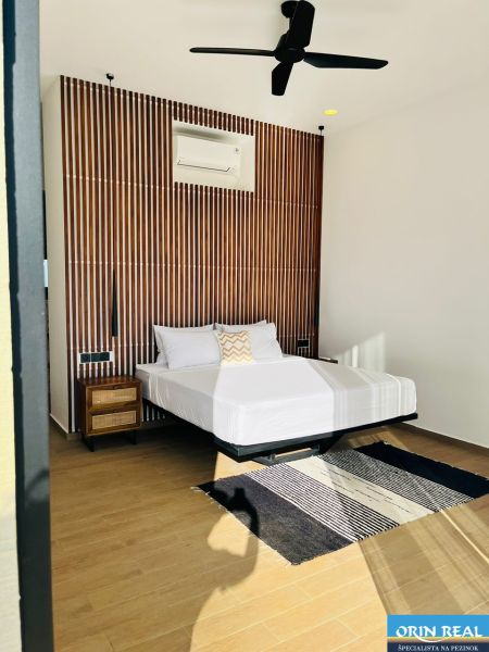 VILA AURA – FREE HOLD VLASTNÍCTVO S PRIAMYM VÝHĽADOM NA SOPKU AGUNG - Spálňa v rodinnom dome so vzorovanou stenou, ventilátorom, kobercom a podlahou s dreveným dekorom.