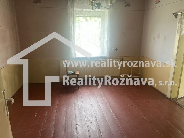 Rodinný dom zo záhradou - Rudná - Izba v rodinnom dome s drevenou podlahou, steny pastelových farieb, okno s bielou záclonou.