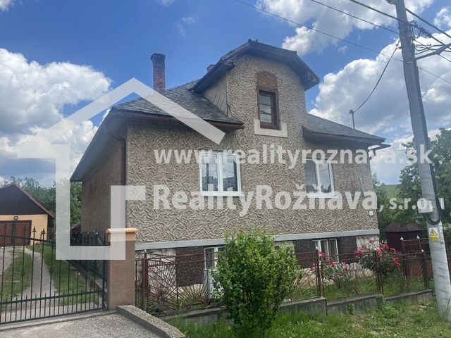 Rodinný dom zo záhradou - Rudná - Rodinný dom v Rudnej s dvojpodlažnou fasádou, oploteným pozemkom a modrou oblohou.