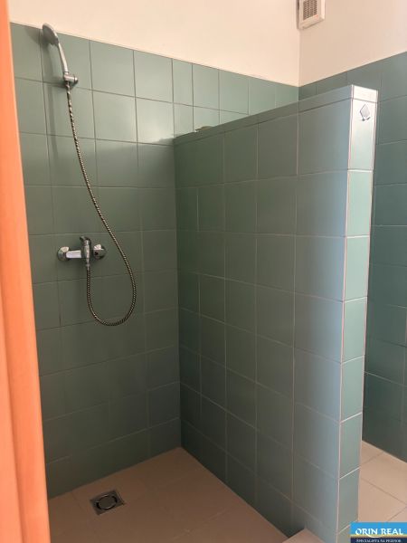 ZARIADENÁ GARSONKA NA SEVERE - Sprchovací kút s tyrkysovými obkladačkami v garsónke.
