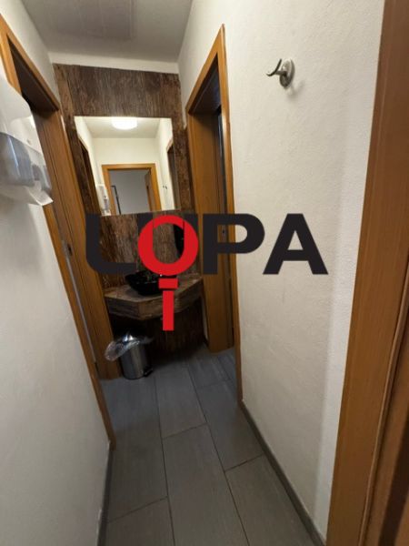 Podnikateľské priestory v  širšom centra mesta Nové Zámky, prízemie - Chodba obchodných priestorov s tmavou podlahou a bielymi stenami.