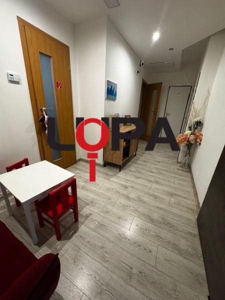 Podnikateľské priestory v  širšom centra mesta Nové Zámky, prízemie - Interiér obchodných priestorov s podlahou s dreveným dekorom a detským kútikom.