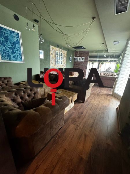Podnikateľské priestory v  širšom centra mesta Nové Zámky, prízemie - Interiér obchodných priestorov s pohodlnými sedačkami a podlahou s dreveným dekorom.