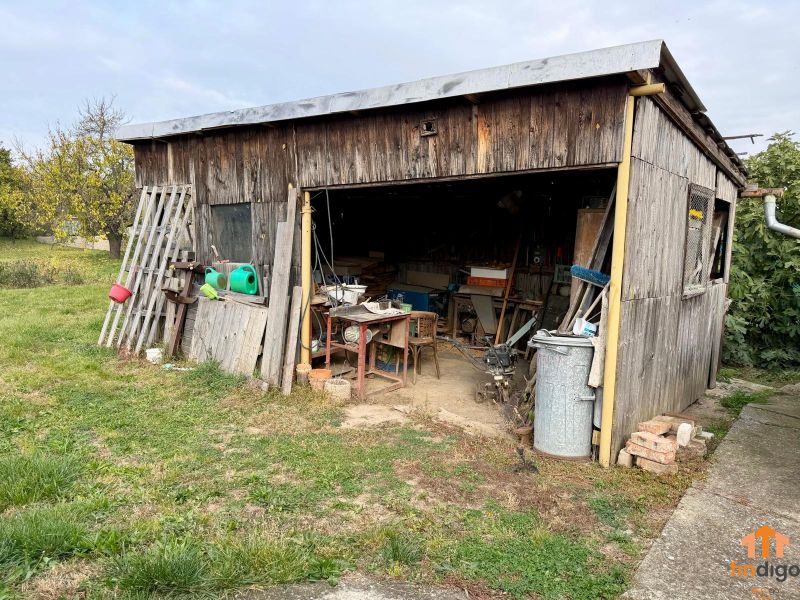 PREDAJ - Veľký rodinný dom s krásnym pozemkom – Pata (20 km od Nitry) - Drevená šopa pri rodinnom dome na Hlohoveckej ulici v obci Pata, obklopená trávou.