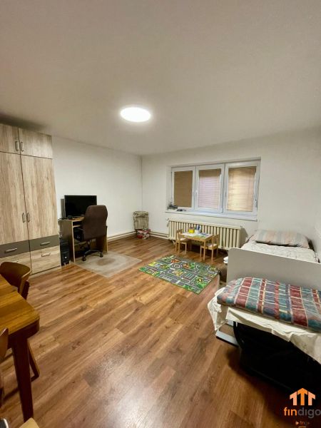 PREDAJ - Veľký rodinný dom s krásnym pozemkom – Pata (20 km od Nitry) - Obývacia izba s podlahou s dreveným dekorom v rodinnom dome, obsahujúca posteľ a pracovný stôl.