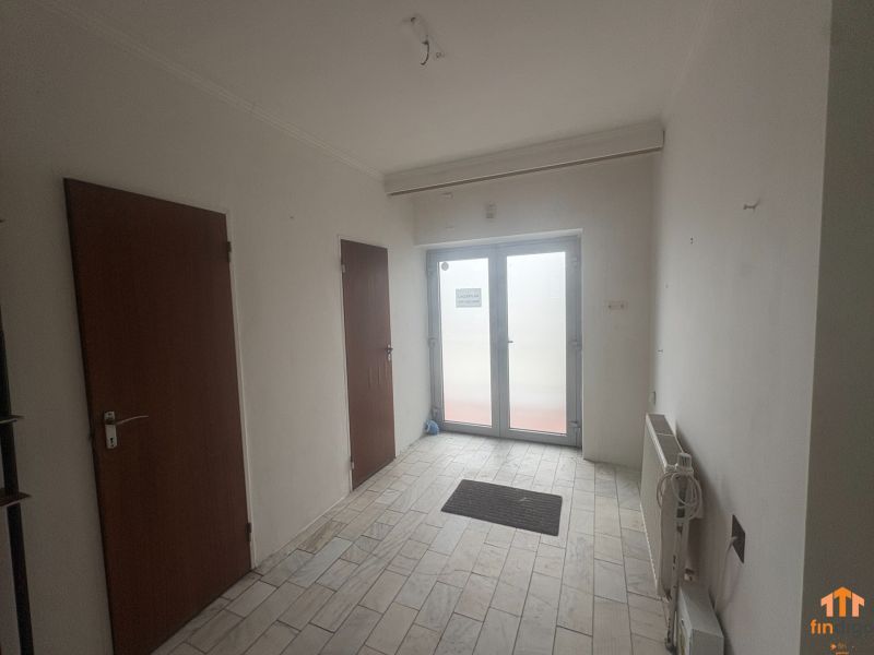 PREDAJ - Rodinný dom s investičným potenciálom - Nové Zámky - Interiér rodinného domu s bielymi stenami, keramickou podlahou a drevenými dverami.