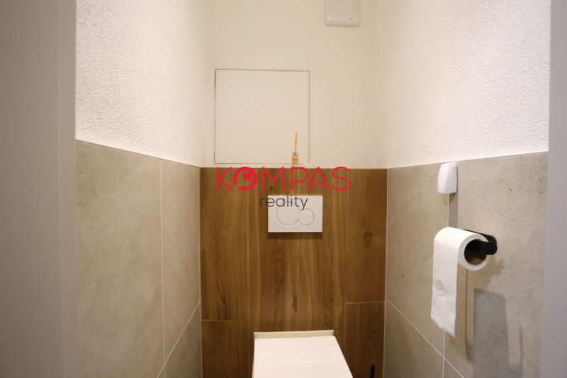 MODERNÝ  2-IZB.BYT PO KOMPLETNEJ REKONŠTRUKCII, UŽ LEN BÝVAŤ - Kúpeľňa v 2-izbovom byte s podlahou s dreveným dekorom a toaletou.