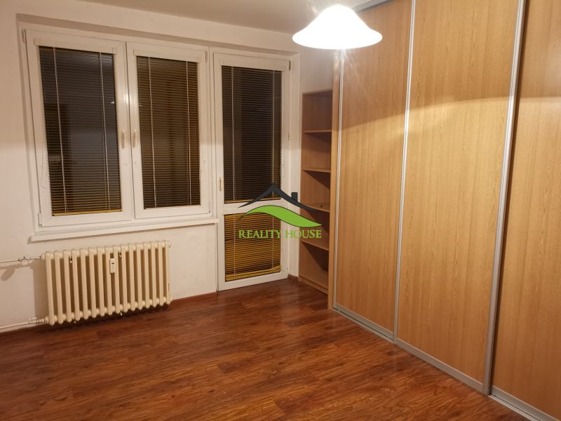 REZERVOVANÉ - Izba s podlahou s dreveným dekorom a veľkou vstavanou skriňou v 3-izbovom byte.