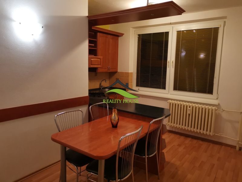 REZERVOVANÉ - Kuchyňa v 3-izbovom byte s podlahou s dreveným dekorom a jedálenským stolom.