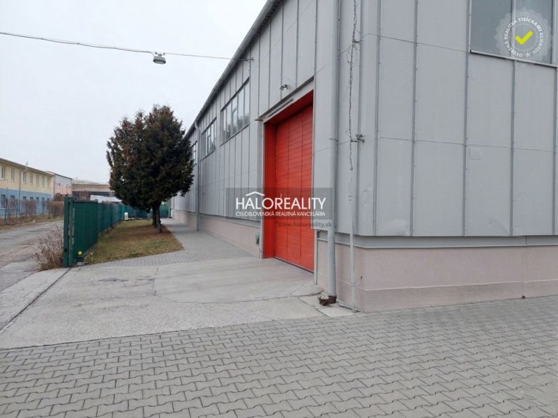 Prenájom, skladový priestor Košice Džungľa - Exteriér kancelárií v KE - Džungľa s červenými dverami a chodníkom z dlažby.