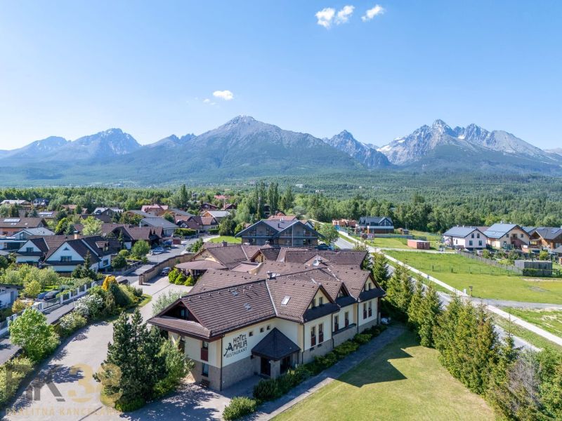 NA PREDAJ: Zabehnutý hotel Amália s wellnesom v srdci Vysokých Tatier - Pohľad na Hotely a penzióny v Novej Lesnej s panorámou Tatier.