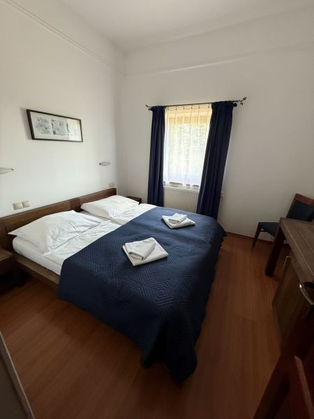NA PREDAJ: Zabehnutý hotel Amália s wellnesom v srdci Vysokých Tatier - Izba s dvojlôžkom, modrou prikrývkou a podlahou s dreveným dekorom v Hoteloch a penziónoch.