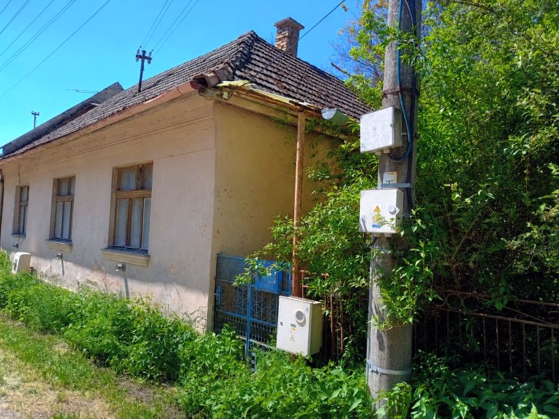 Rodinný dom, pozemok 4282m2 KĽAČNO okr. Prievidza, - Rodinný dom v Kľačne s klesajúcou škridlovou strechou a bujnou vegetáciou okolo.
