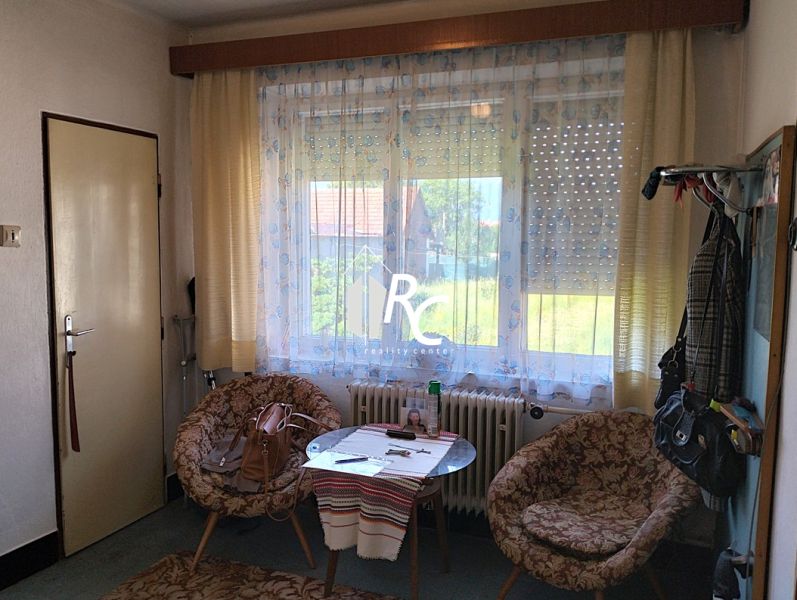 Rodinný dom, Sučany - Izba v rodinnom dome so stolom, stoličkami a veľkým oknom s výhľadom.