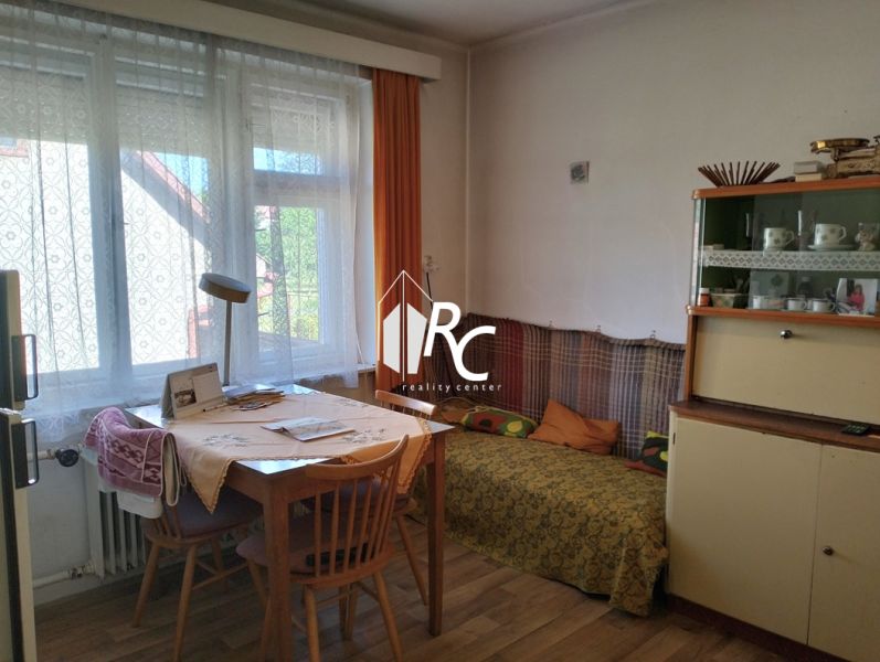 Rodinný dom, Sučany - Interiér rodinného domu s jedálenským stolom a podlahou s dreveným dekorom.