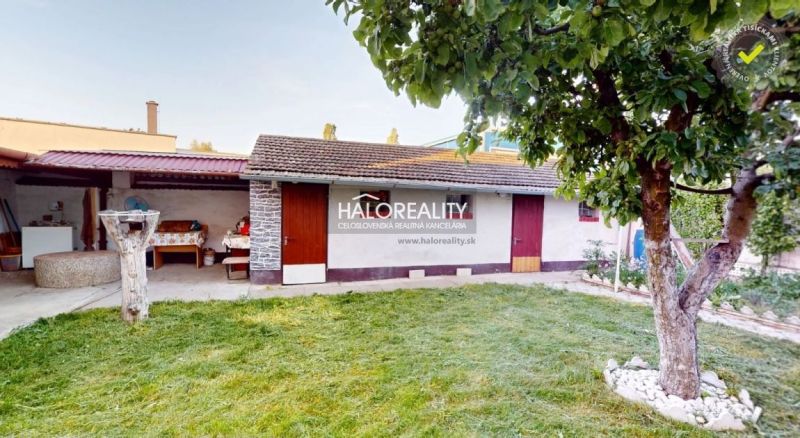 Predaj, rodinný dom Senica - EXKLUZÍVNE HALO REALITY - Záhrada pri rodinnom dome v Senici s trávnikom a stromom, prístavba vzadu.