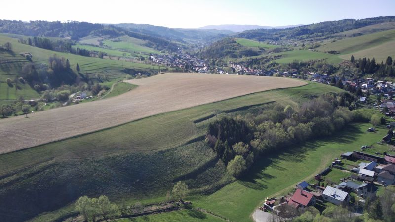 Čierny Balog – 338 m2 POĽNOHOSPODÁRSKY pozemok v 1/1 - Krajina v Čiernom Balogu s poľnohospodárskymi a lesnými pozemkami na svahoch kopcov.