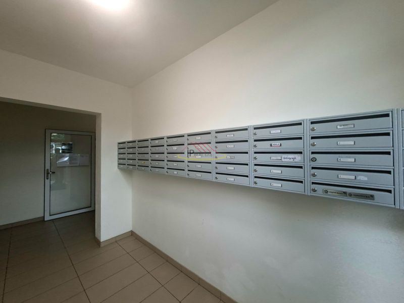 Priestranná garzónka s balkónom v novostavbe. - Schránky vo vstupnej hale garsónky, podlaha s dlažbou, jednoduchý dizajn.