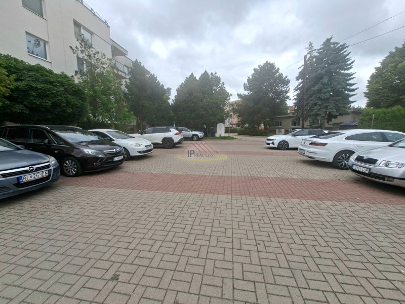 Priestranná garzónka s balkónom v novostavbe. - Parkovisko s autami na Športovej ulici v Dunajskej Lužnej pred budovou.