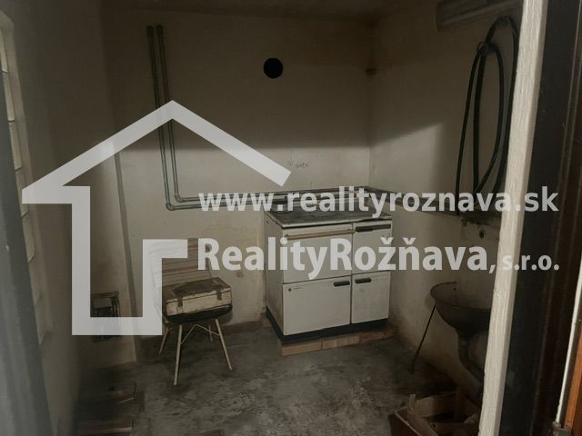 PREDAJ/ Krásna chalupa s vinicou/Jablonov nad Turňou - Malá miestnosť s kuchynským sporákom, umývadlo a betónová podlaha, vhodná pre chatu.