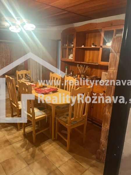 PREDAJ/ Krásna chalupa s vinicou/Jablonov nad Turňou - Jedálenský kút v chate s dreveným stolom a stoličkami, osvetlený luster.