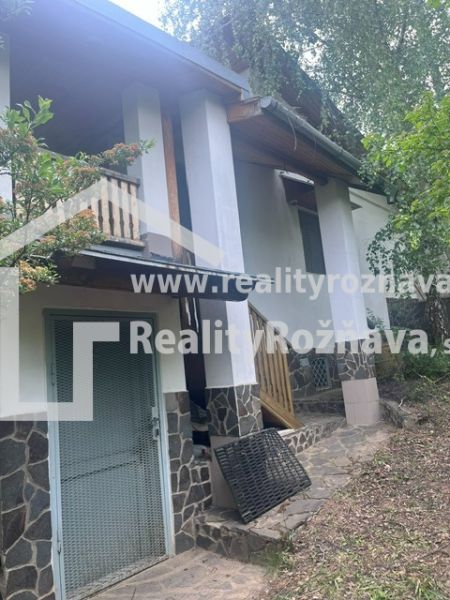 PREDAJ/ Krásna chalupa s vinicou/Jablonov nad Turňou - Chata v Jablonove nad Turňou, obklopená zeleňou, s terasou a kamenným obkladom.