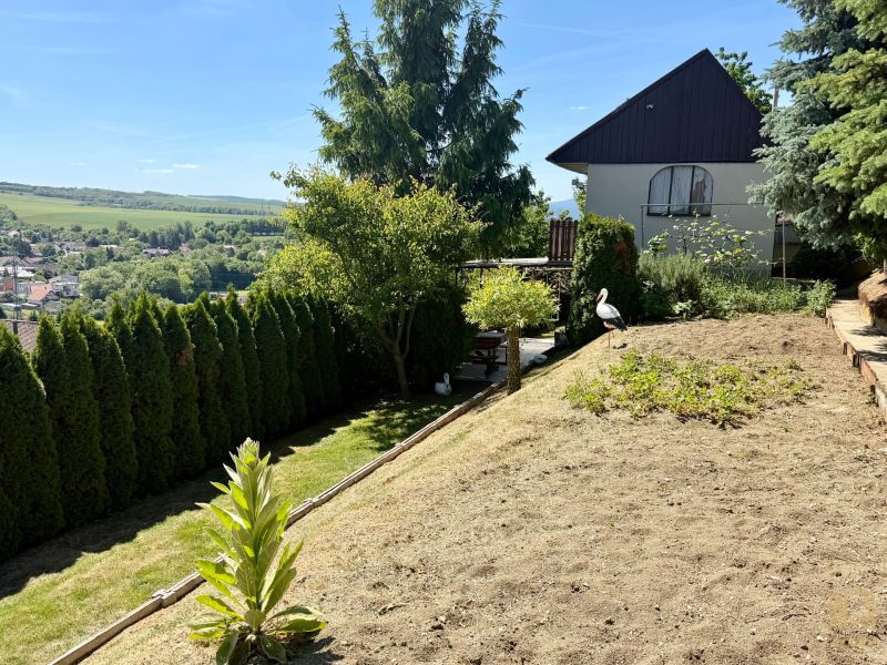 REZERVOVANÁ / Záh. chata s altánkom, pozemok 534m2, ZO Kunov I, Senica - Záhrada pri chate v Kunove, Senica s výhľadom na okolitú krajinu a dedinu.