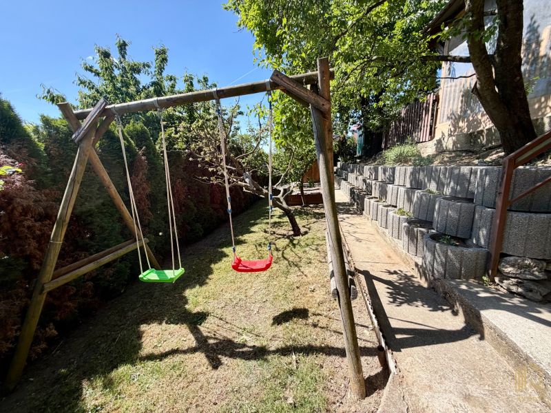 REZERVOVANÁ / Záh. chata s altánkom, pozemok 534m2, ZO Kunov I, Senica - Drevené hojdačky na dvore chaty v Kunove, Senica, s terasovitým usporiadaním záhrady.